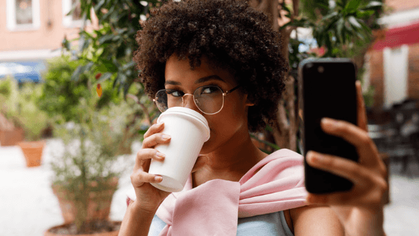 morena tomando café e tirando foto