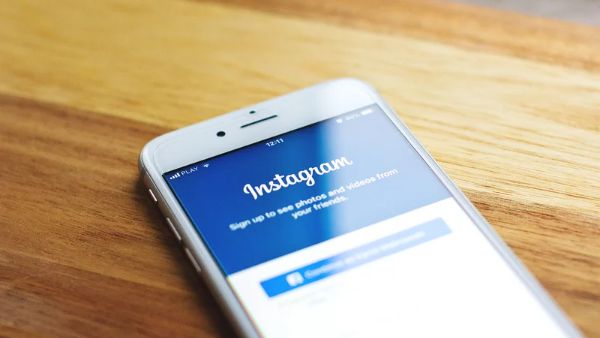 celular sobre mesa na tela de login do instagram