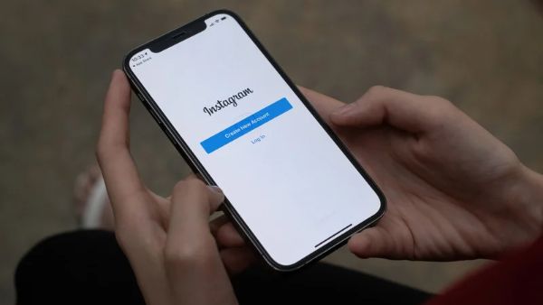 pessoa usando celular na tela de login do instagram