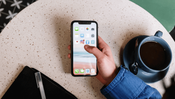 celular na área de trabalho ao lado do café